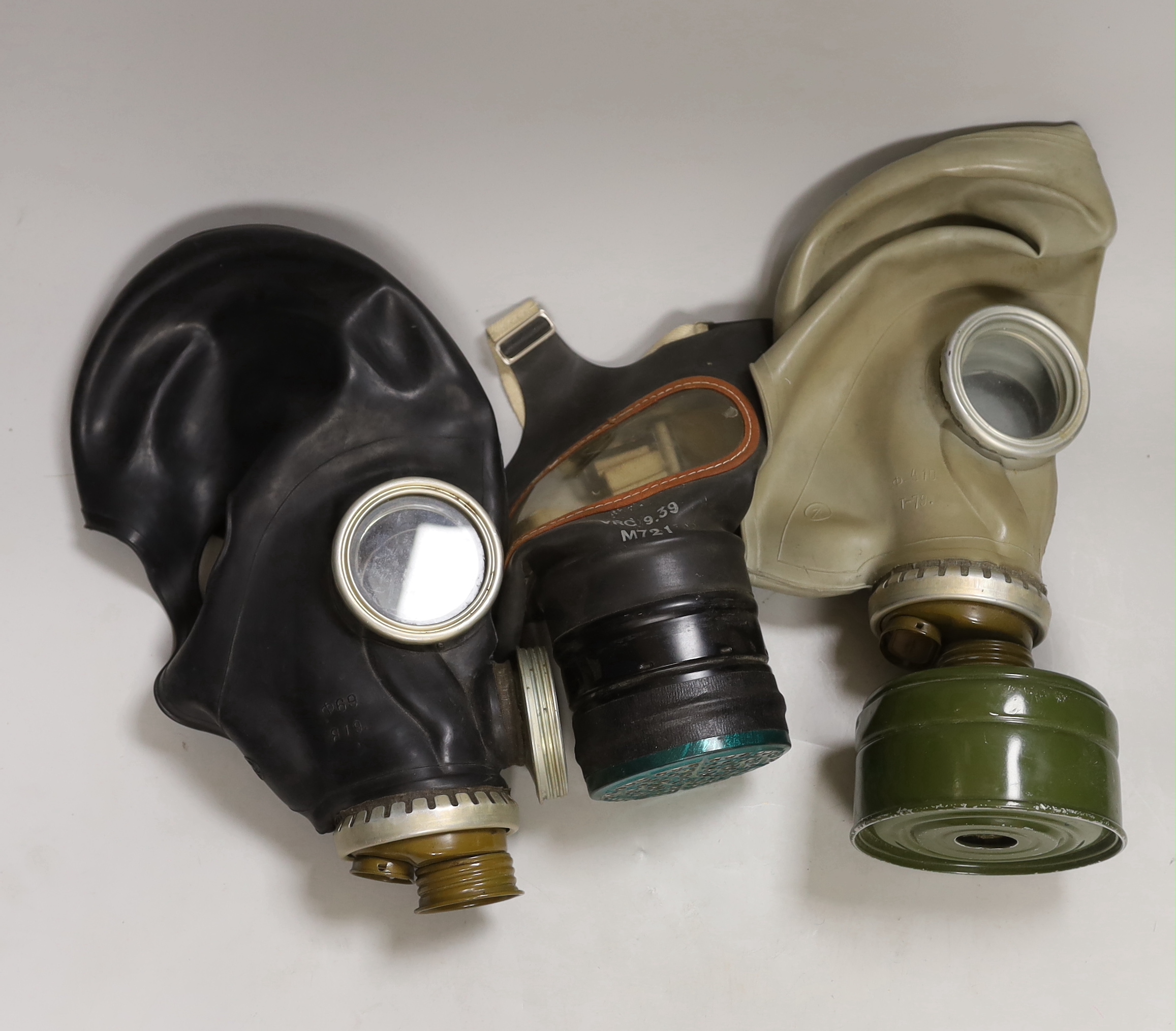 Three gas masks, including a boxed child’s mask with instructions on inside of the lid